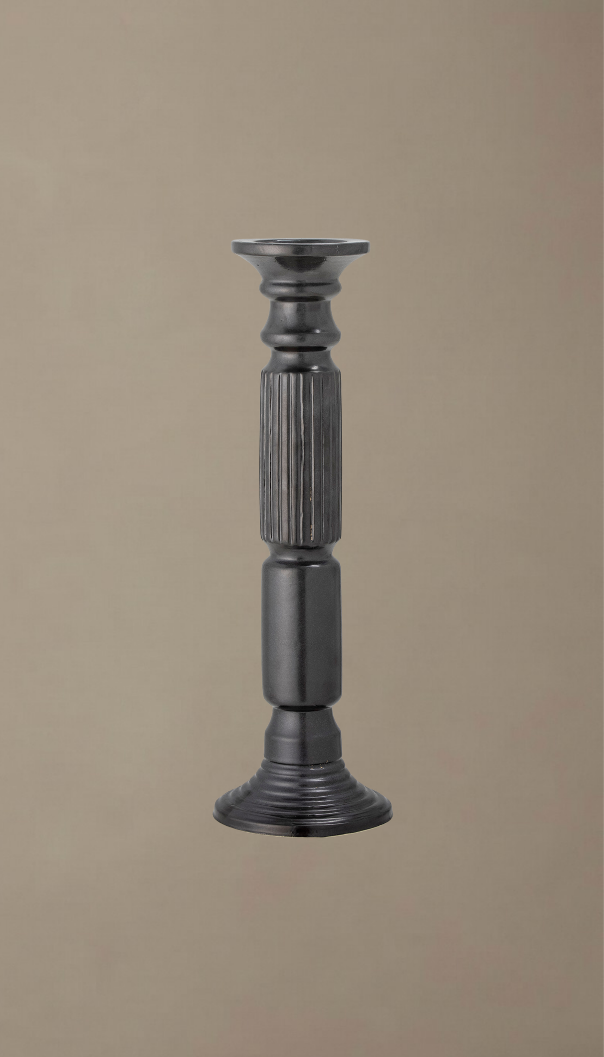 Candelabro alto de cerámica modelo Laurel en color negro satinado, con diseño torneado clásico y sección central estriada, sosteniendo una vela de pilar color crema.