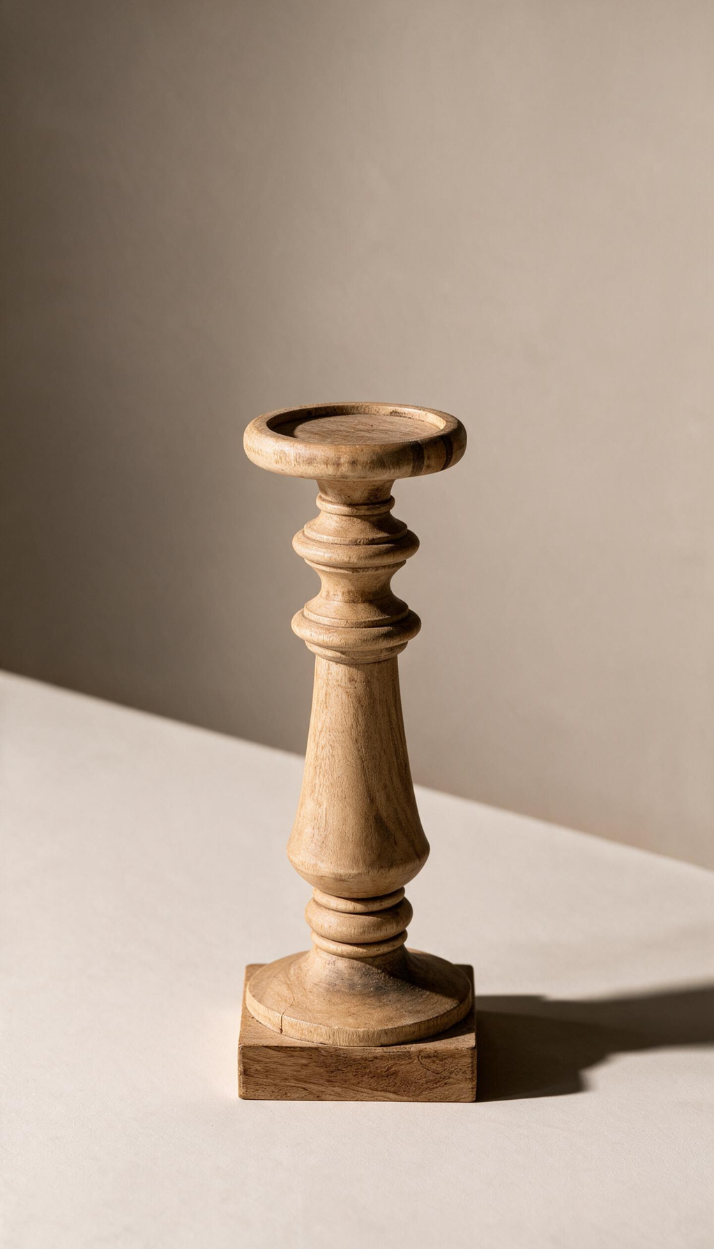 Pedestal de madera natural modelo Jara con diseño clásico torneado, base cuadrada y plato superior redondo, utilizado como portavelas de estilo rústico.
