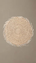 Salvamantel redondo modelo Priego visto desde arriba, trenzado en fibras naturales de seagrass con diseño en espiral y bordes terminados con flecos rústicos.