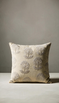 Cojín cuadrado de algodón modelo Vejer en color beige claro, decorado con un elegante patrón de flores clásicas bordadas en relieve tono sobre tono.